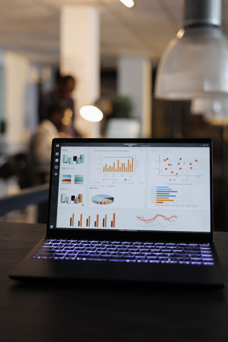 Laptop computer with marketing statistics graphs on screen